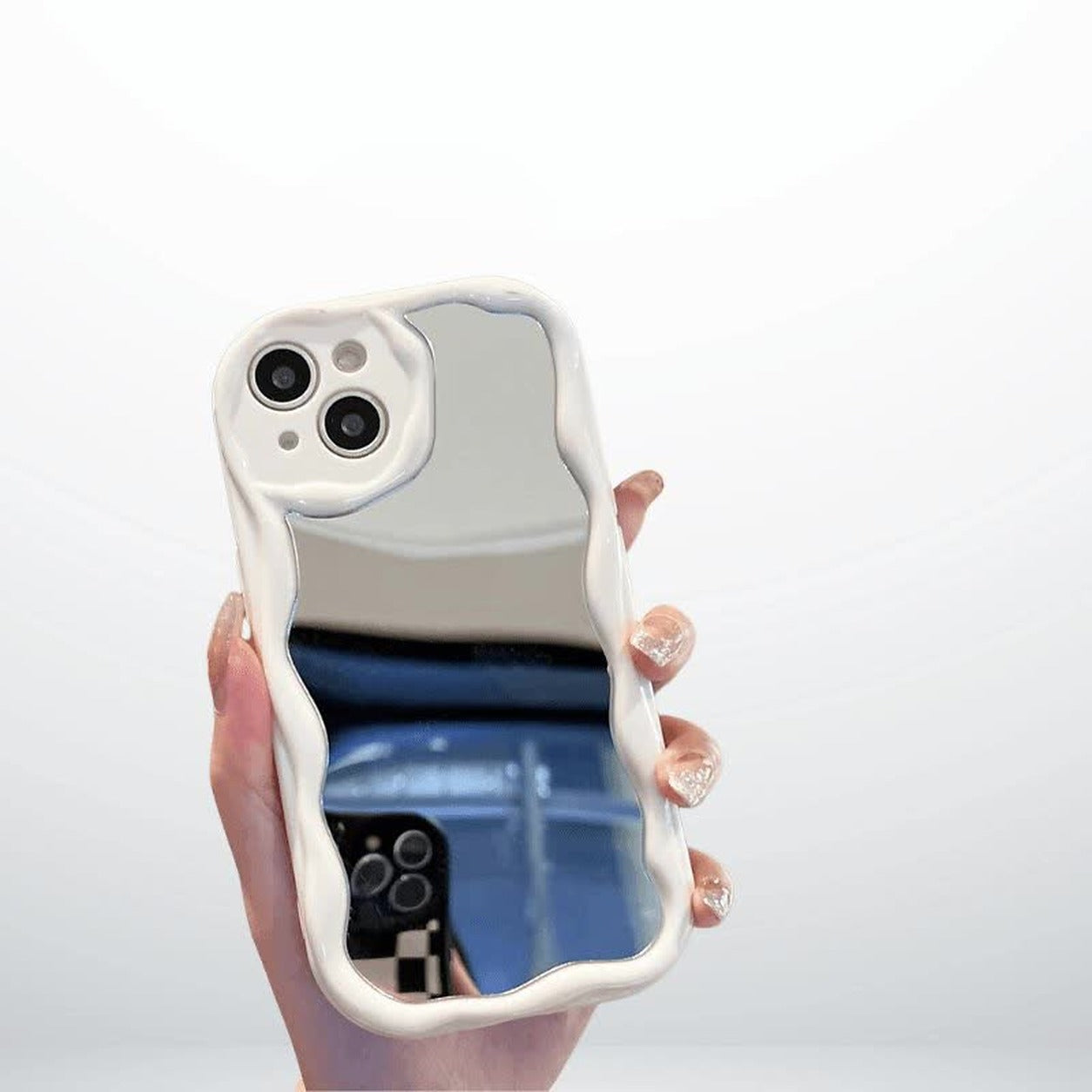 Étui miroir blanc pour iPhone tenu en main